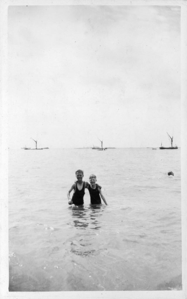 '2 boys in sea' - a few clues here only, Thames sailing barges moored aup in background; what appears to be a pier in background (Southend?)